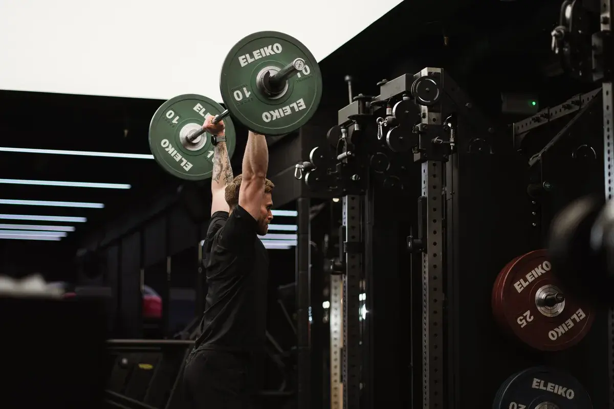 An overhead barbell press in the gym